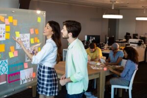 A man and woman collaborating in their office on a board