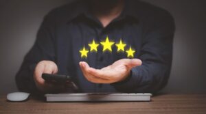 man holding a mobile phone in one hand and 5 stars in another